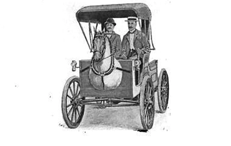 skeuomorphism: image of two men sitting in Smith’s Horsey Horseless automobile, a vehicle with a life-size replica of a horse's head and shoulders attached to the front.