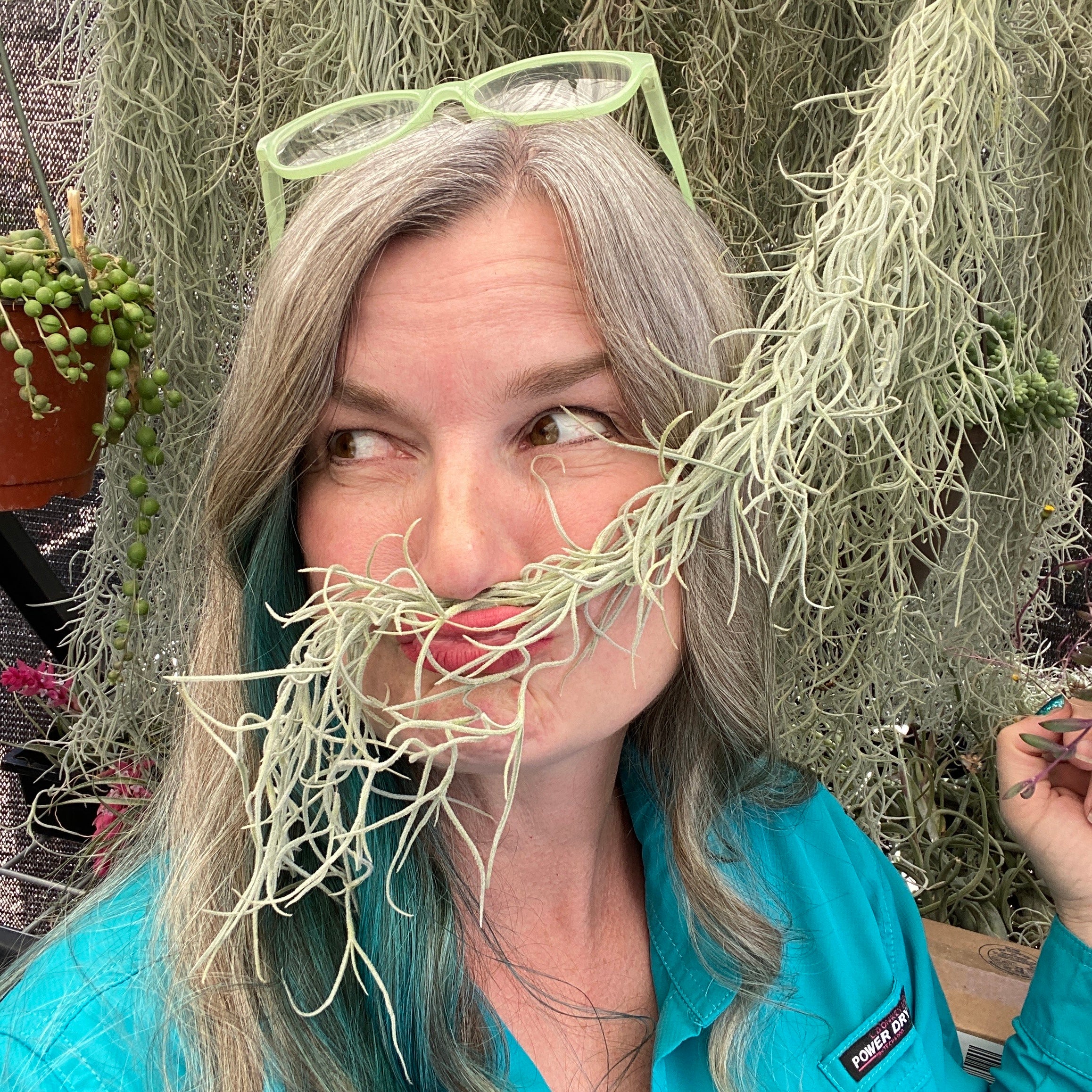 Portrait of Partly Sunny Projects' founder Sonja using a plant as a moustache