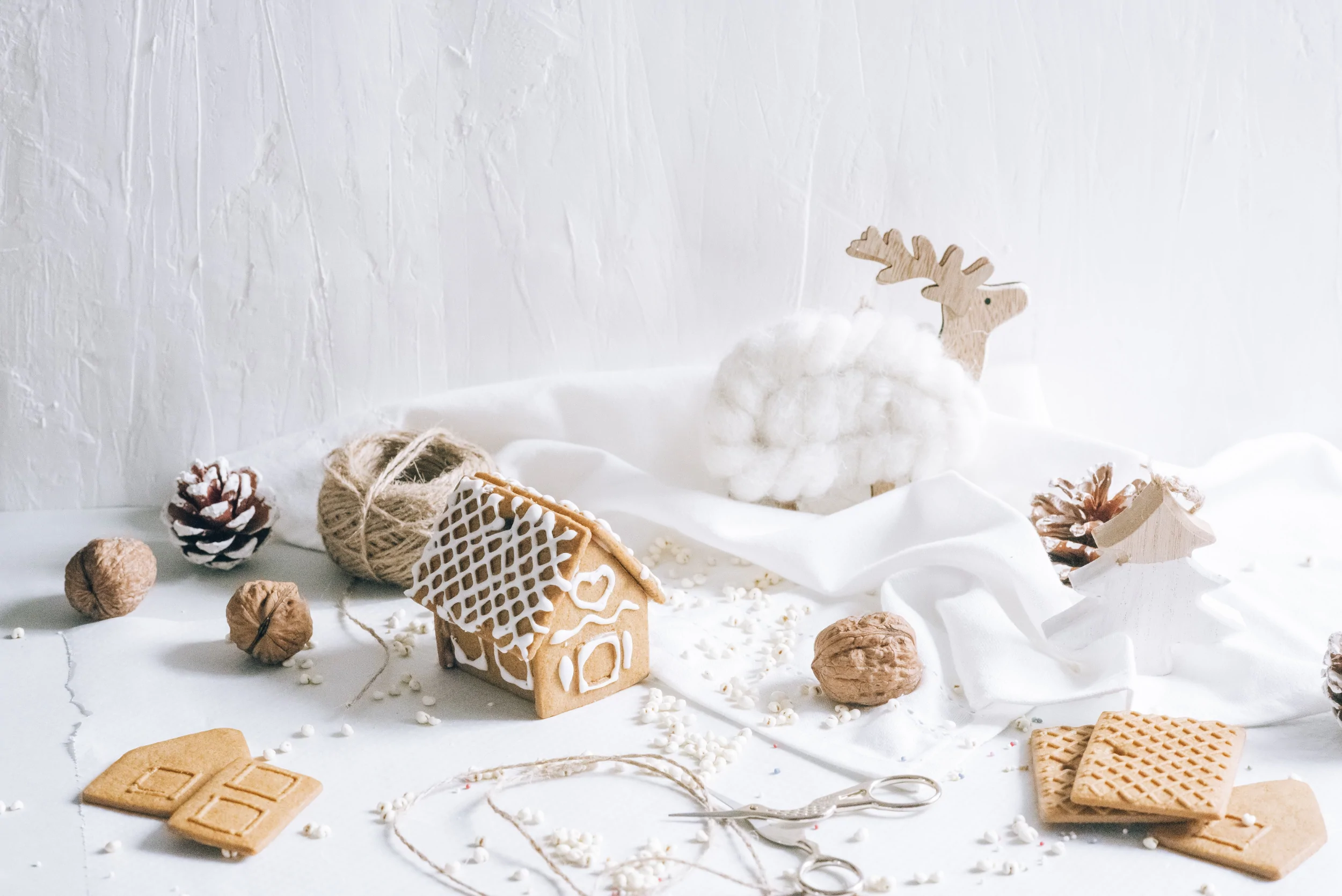 Array of natural colored holiday items including treats and ornaments on a white surface